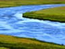 The steaming Firehole River in contrast to the cool prairie grasses.
