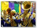 Another marching band announces the arrival of the foil-clad Mid-City krewe.